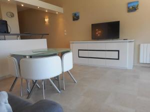 a living room with a table and a tv on a cabinet at Appartement Villeneuve-Loubet, 2 pièces, 4 personnes - FR-1-252A-9 in Villeneuve-Loubet