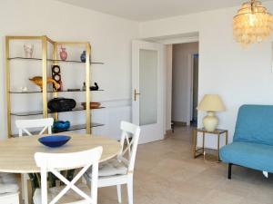 a living room with a table and a blue couch at Appartement Le Lavandou, 2 pièces, 4 personnes - FR-1-251-287 in Le Lavandou