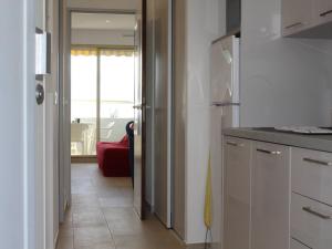 une cuisine avec une porte menant à un salon dans l'établissement Appartement Villeneuve-Loubet, 1 pièce, 2 personnes - FR-1-252A-19, à Villeneuve-Loubet