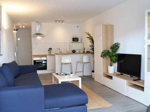 a living room with a blue couch and a kitchen at Appartement Le Lavandou, 1 pièce, 3 personnes - FR-1-251-303 in Le Lavandou