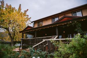 a large wooden house with a balcony and trees at Salt Spring Inn in Ganges
