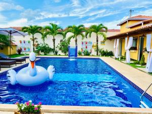 a swimming pool with a white swan in the middle at Villa Paradise in Brazil - Praia de Guaratiba Prado-BA in Prado