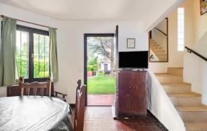 a bedroom with a bed and a television and a staircase at Dúplex complejo - Centro Villa Gesell - 5 huéspedes in Villa Gesell