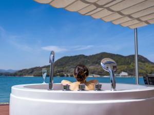 a doll sitting in a bath tub with water at 瀬戸内隠れ家リゾート in Onomichi +40 photos