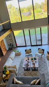 ein Wohnzimmer mit einem Sofa, Tischen und Fenstern in der Unterkunft Casa Familiar Puerto Varas in La Ensenada