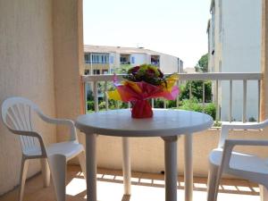 een tafel met een vaas met bloemen op een balkon bij Appartement Fréjus, 2 pièces, 4 personnes - FR-1-226A-366 in Fréjus