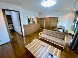 un soggiorno con un divano e un tavolo di Hotel EL 8（宇都宮駅東口） a Utsunomiya