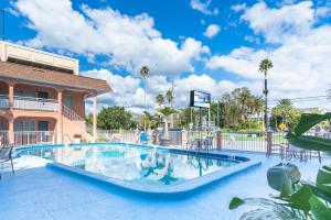 uma piscina num resort com cadeiras e um edifício em Echo Sails Motel em Clearwater Beach