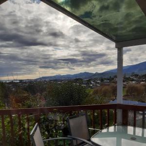 a balcony with a table and chairs and mountains at Hillview Homestay in Richmond
