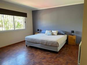 Un dormitorio con una cama grande y una ventana en Casa Velvet, en la mejor zona residencial en Mendoza