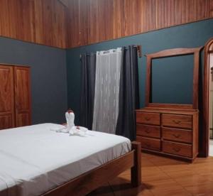 a bedroom with a bed with a dresser and a mirror at Casa Tabacón in Puerto Jiménez