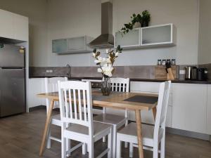 a kitchen with a wooden table and white chairs at Waverley apartment E-one bedroom wifi available in Perth