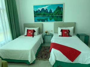 two beds with red pillows in a room at MCITI Suites in Miri