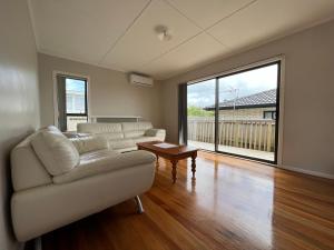 a living room with a couch and a table at Yucca Home in Auckland