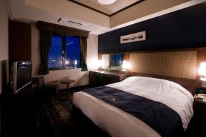 a hotel room with a bed and a television at Hotel Monterey Grasmere Osaka in Osaka
