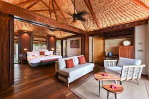 a living room with two beds and a couch at Le Bora Bora by Pearl Resorts in Bora Bora