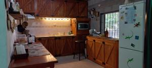 a kitchen with wooden cabinets and a white refrigerator at La Chelca in San Fernando del Valle de Catamarca