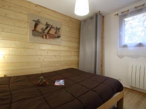 a bedroom with a bed with a teddy bear sitting on it at Appartement Vallouise-La Casse, 2 pièces, 6 personnes - FR-1-330G-57 in Le Poët