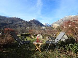 two chairs and a table in the grass with mountains at Appartement Vallouise-La Casse, 2 pièces, 6 personnes - FR-1-330G-57 in Le Poët