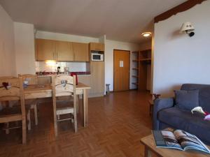 eine Küche und ein Wohnzimmer mit einem Tisch und einem Sofa in der Unterkunft Appartement Puy-Saint-Vincent, 2 pièces, 6 personnes - FR-1-330G-14 in Puy-Saint-Vincent