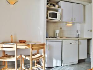 une petite cuisine avec une table et un four micro-ondes dans l'établissement Appartement Le Lavandou, 1 pièce, 4 personnes - FR-1-251-263, au Lavandou