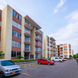 a parking lot with cars parked in front of a building at Apartamento vacacional en Flandes tolima in Flandes