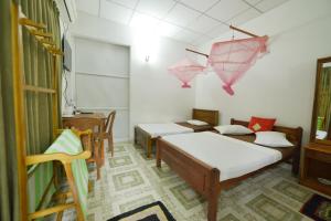 Habitación con 4 camas, mesa y sillas en Venus Resorts en Danwilana