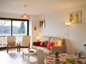 a living room with a couch and a table at Le Lavandou : T2 avec 4 couchages, terrasse, parking en option, animaux admis - FR-1-251-212 in Le Lavandou