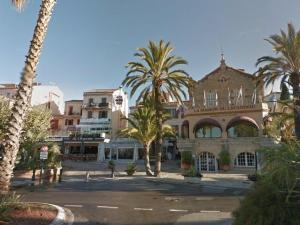 a large building with palm trees in front of it at Le Lavandou : T2 avec 4 couchages, terrasse, parking en option, animaux admis - FR-1-251-212 in Le Lavandou +12 photos