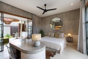 - une chambre avec un lit, une table et un miroir dans l'établissement 4BR Pererenan Villa, à Munggu