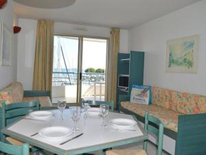 a dining room with a table with wine glasses on it at Fréjus: Appt 2P, 5 pers, Piscine, Plage à 150m, Parking, Animaux OK - FR-1-226A-357 in Fréjus