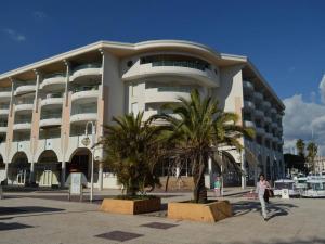 a woman walking in front of a large building at Fréjus: Appt 2P, 5 pers, Piscine, Plage à 150m, Parking, Animaux OK - FR-1-226A-357 in Fréjus