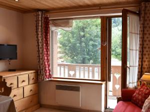 uma sala de estar com uma grande janela e uma varanda em Appartement Méribel, 1 pièce, 4 personnes - FR-1-180-372 em Les Allues