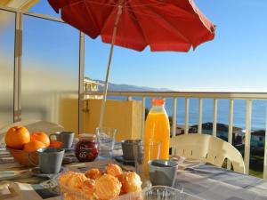 una mesa con naranjas y una botella de zumo de naranja en Appartement Le Lavandou, 1 pièce, 4 personnes - FR-1-251-251, en Le Lavandou