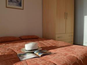 a hat on top of a bed with a book at Appartement Le Lavandou, 1 pièce, 4 personnes - FR-1-251-251 in Le Lavandou