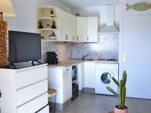 a kitchen with white cabinets and a dishwasher at Appartement Le Lavandou, 1 pièce, 4 personnes - FR-1-251-232 in Le Lavandou
