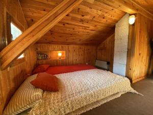 a bedroom with a bed in a wooden attic at Chalet familial 12 pers, Arêches-Beaufort, proche commerces - FR-1-342-292 in Beaufort