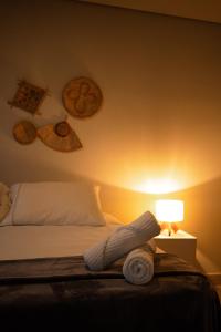 1 dormitorio con 1 cama con lámpara y platos en la pared en Villa Cordel, en Fernando de Noronha