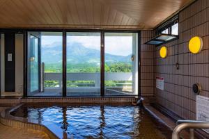 a swimming pool with a view of the mountains at Kyukamura Minami-Aso in Takamori
