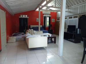a living room with a white couch and red walls at Oase Van Java in Salatiga