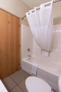 a bathroom with a toilet and a tub and a sink at Rapid River Lodge in Baxter