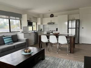 een keuken en een woonkamer met een bank en een tafel bij Alpine Mountain View 41 in Jindabyne