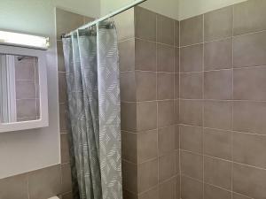 a shower with a shower curtain in a bathroom at Alpine Mountain View 41 in Jindabyne