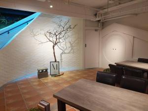 a room with tables and a tree on the wall at Green Hotel - West District in Taichung