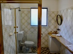 a bathroom with a toilet and a sink and a window at Top Deck by Kristall Apartments in Jindabyne
