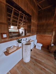 a bathroom with a toilet and a sink in a room at Sumba Beach House in Waikabubak