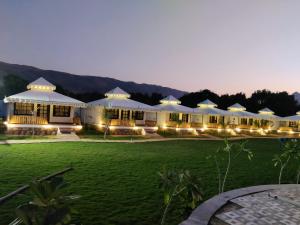 - une vue sur un bâtiment avec une pelouse la nuit dans l'établissement Ananda Resort, à Pushkar
