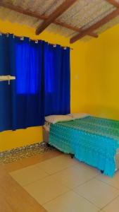 パラチにあるParaty casa suiteのベッドルーム1室(青いカーテン付きのベッド1台付)