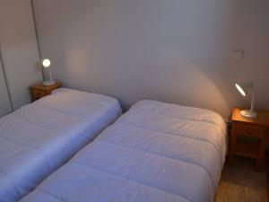 dwa łóżka w małym pokoju z dwoma lampami w obiekcie Appartement Le Grand-Bornand, 2 pièces, 6 personnes - FR-1-241-188 w mieście Le Grand-Bornand