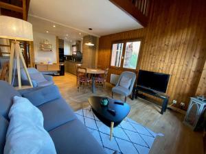 uma sala de estar com um sofá azul e uma cozinha em Appartement Le Grand-Bornand, 2 pièces, 6 personnes - FR-1-241-186 em Le Grand-Bornand